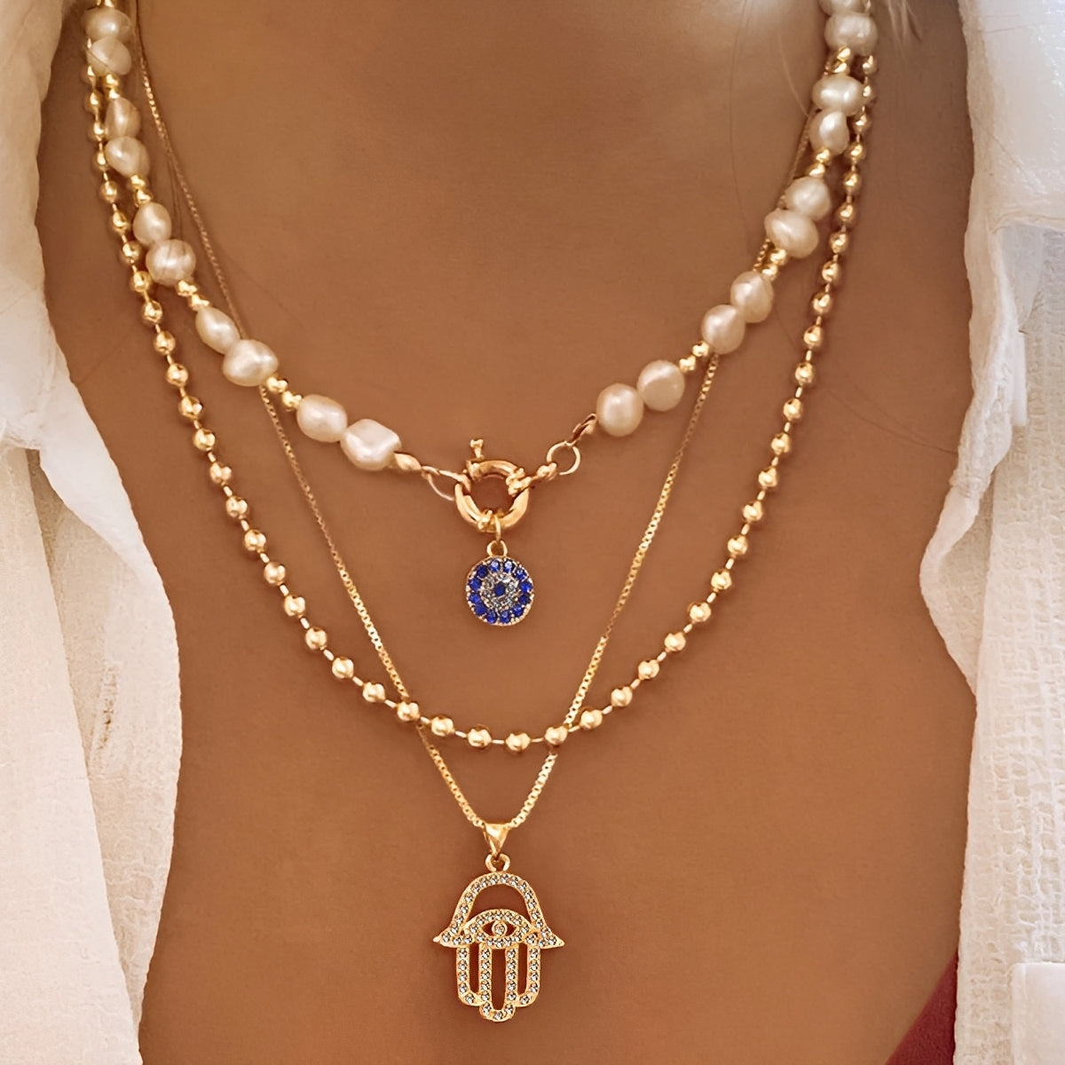 Nadia – Halskette mit mehreren Reihen an Perlen und Hamsa-Hand