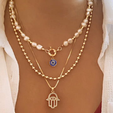 Nadia – Halskette mit mehreren Reihen an Perlen und Hamsa-Hand